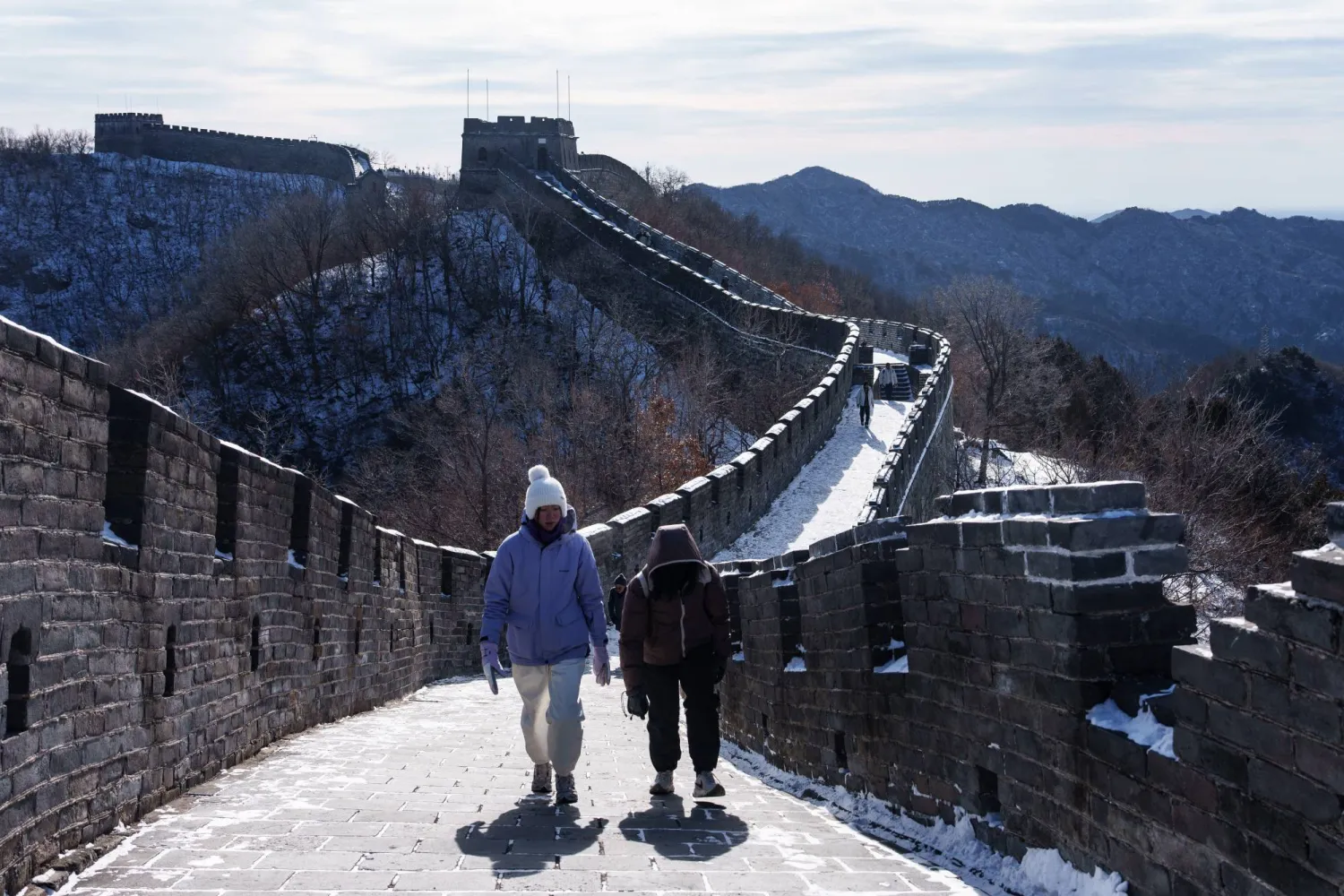 سائحان يسيران فوق سور الصين العظيم على تخوم العاصمة بكين (أ ب)