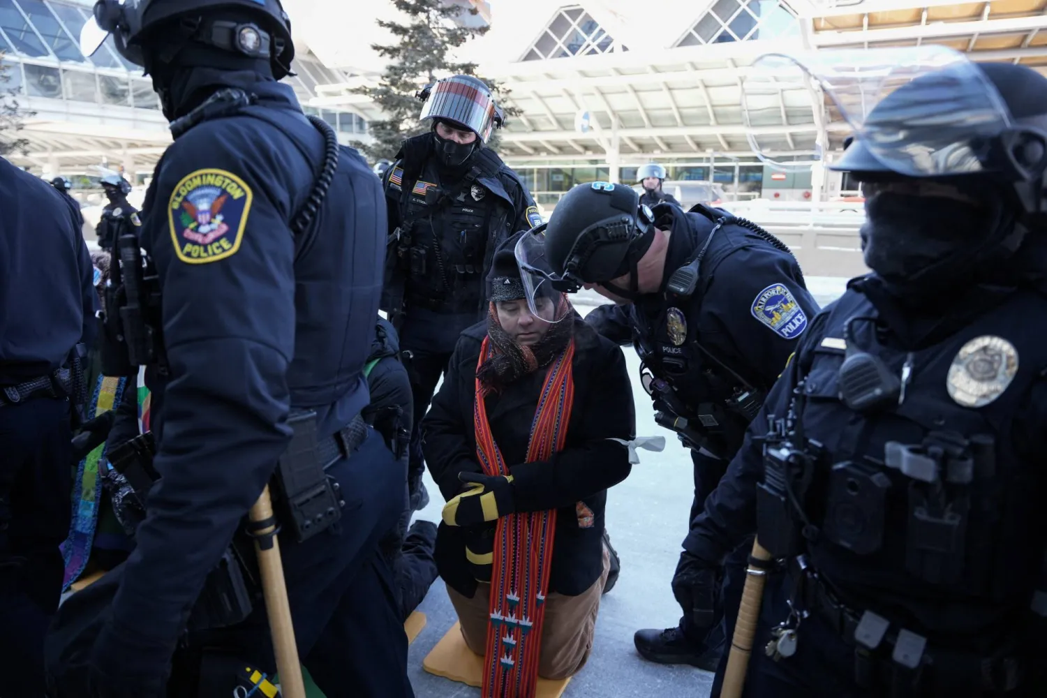 ضباط شرطة أميركيون يعتقلون رجلاً خلال مسيرة احتجاجية ضد قوانين الهجرة في مدينة مينيابوليس بولاية مينيسوتا (رويترز)