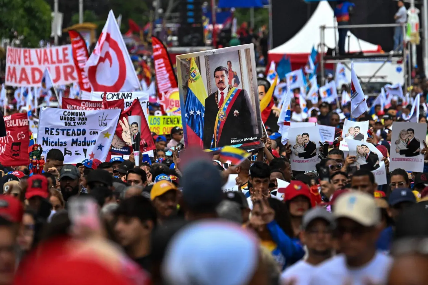 Devrik Venezuela Devlet Başkanı Nicolas Maduro'nun destekçileri, Maduro'nun fotoğraflarını ve serbest bırakılmasını talep eden pankartlar taşıdı (AFP)