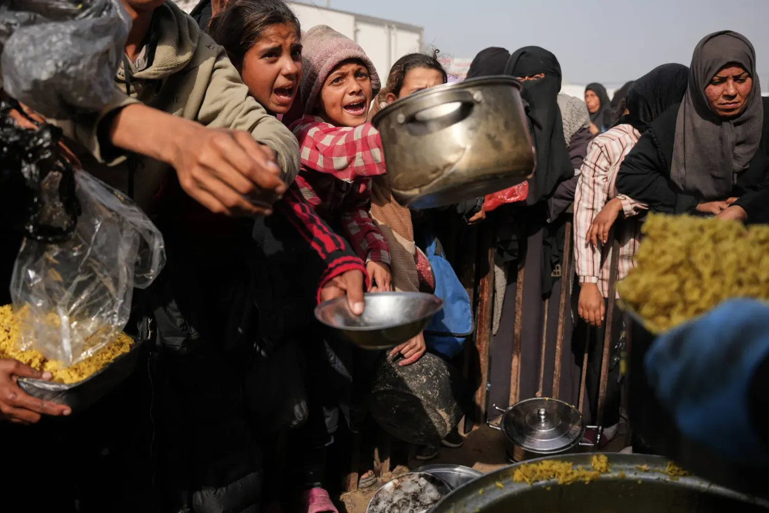Filistinliler, Gazze Şeridi'nin güneyindeki Han Yunus'ta yiyecek almak için bekliyor (AP)