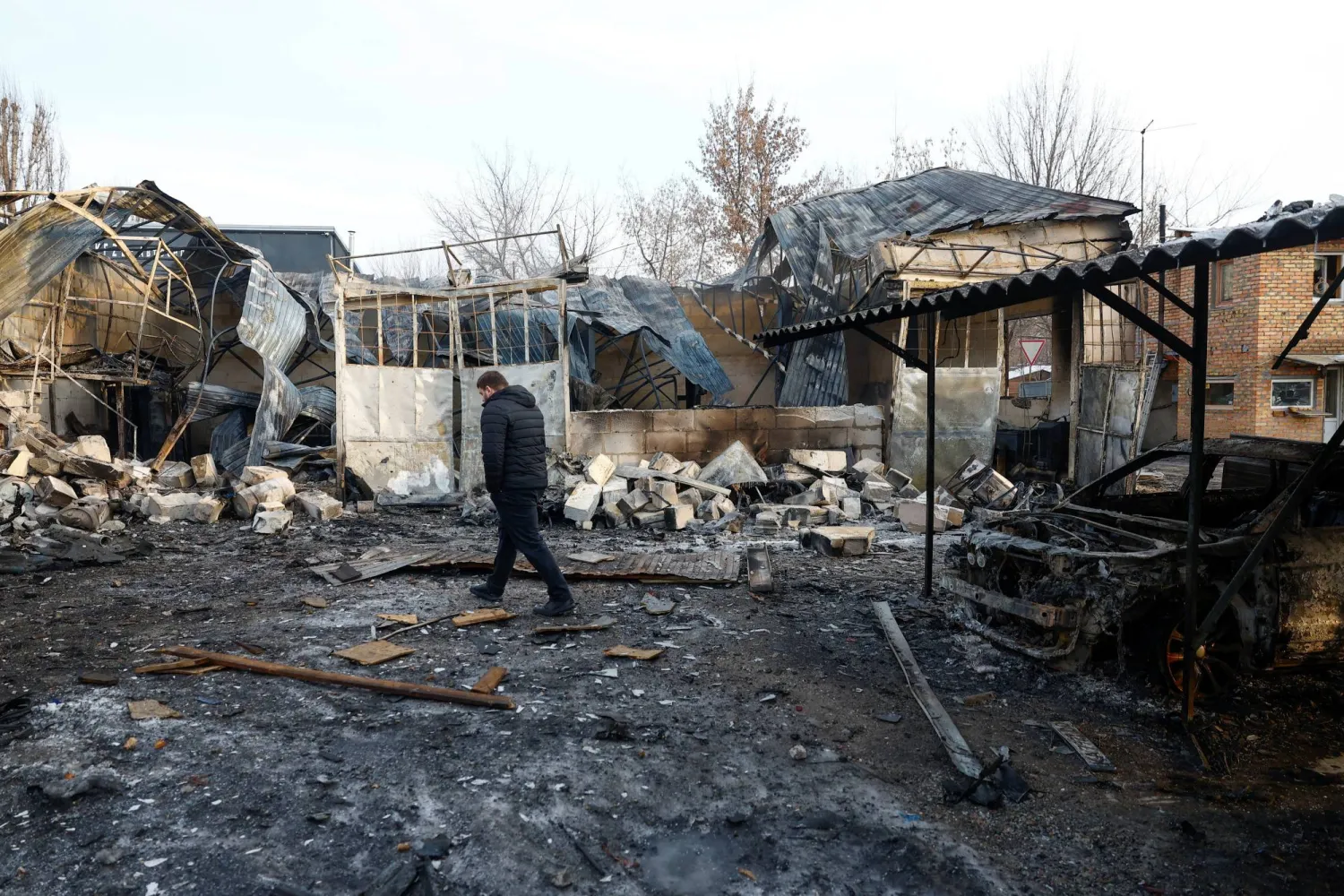 A resident inspects a compound of car workshop and garage hit during Russian overnight drone and missile strikes, amid Russia's attack on Ukraine, in Kyiv, Ukraine January 24, 2026. REUTERS/Valentyn Makarenko
