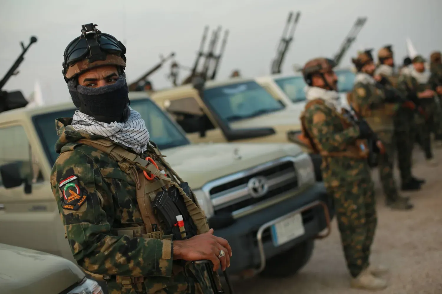 Irak'ın batısındaki el-Kaim'de, Irak-Suriye sınırındaki beton bir duvarın yanında Haşdi Şabi güçleri, (DPA)