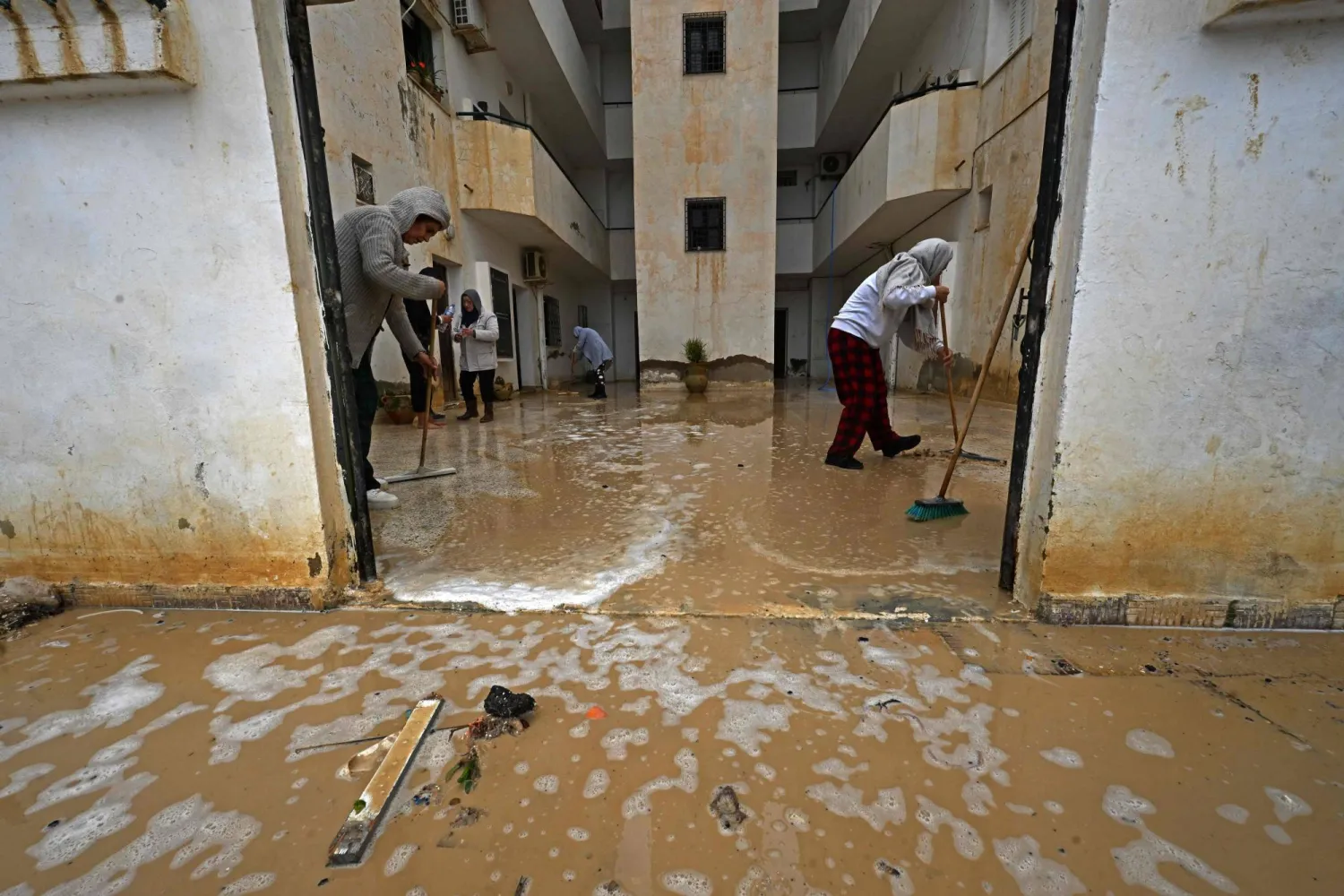 تونسي من منطقة أريانة ينظف آثار السيول (أ.ف.ب)