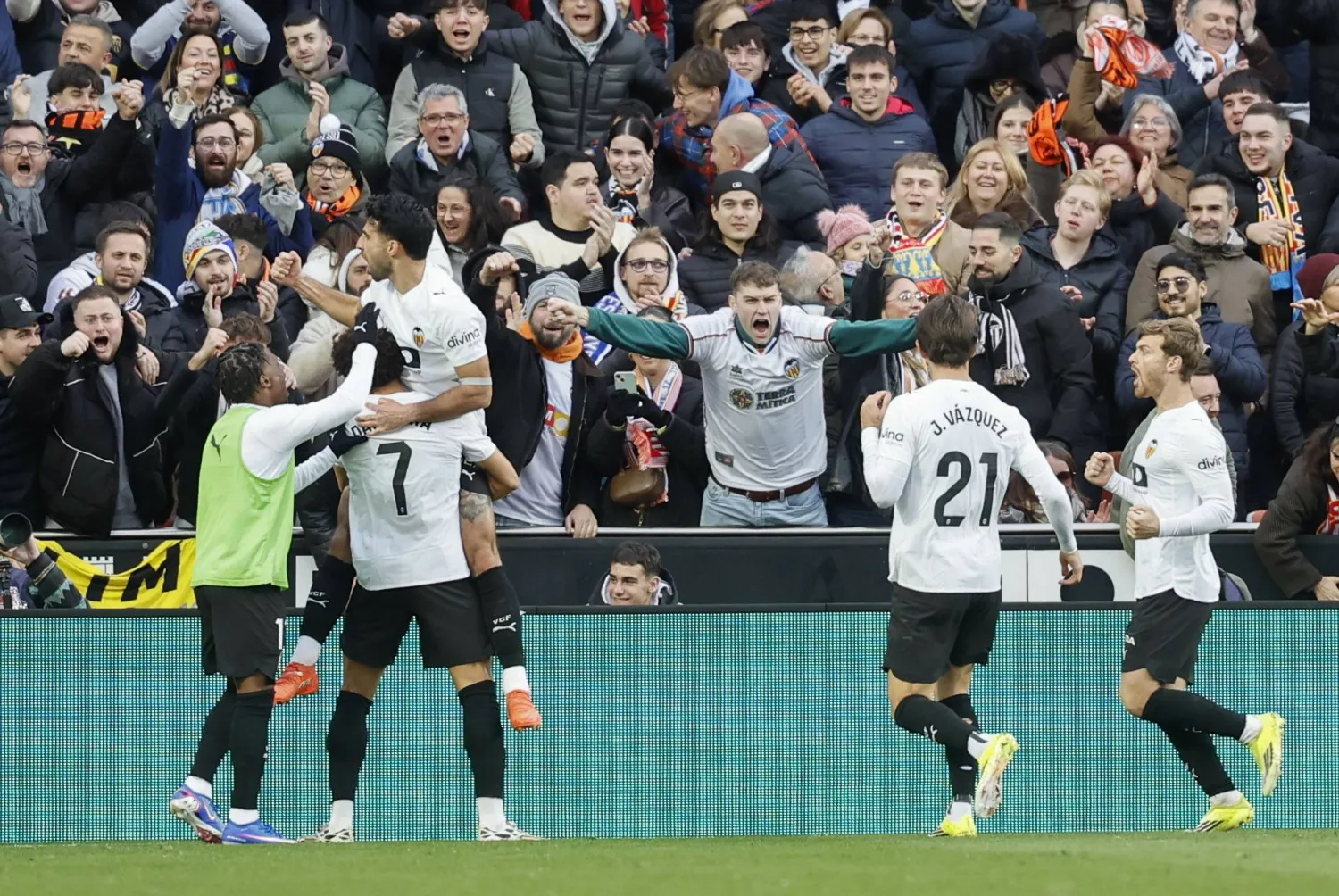 فرحة لاعبي فالنسيا مع جماهيرهم بالفوز على إسبانيول (إ.ب.أ)