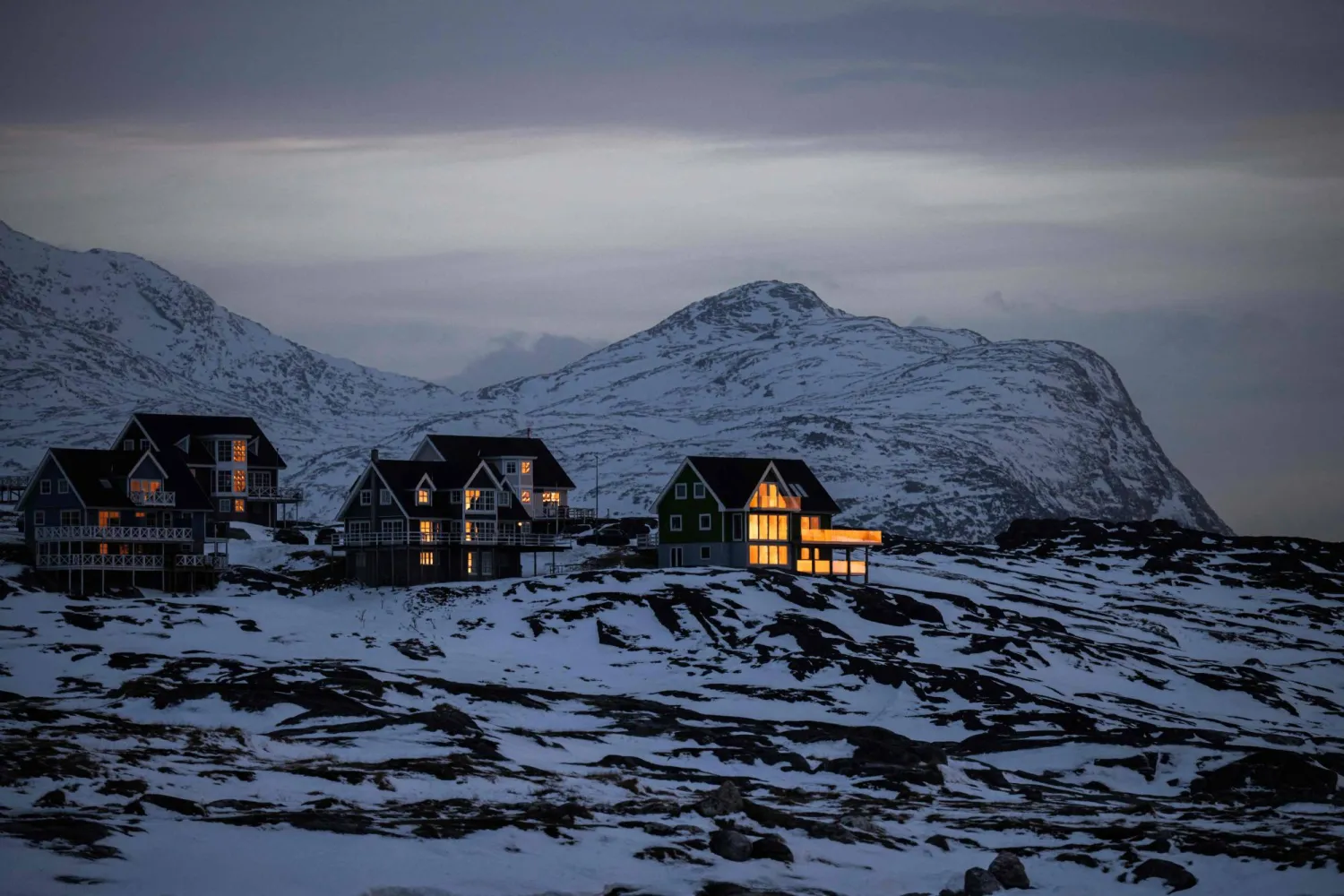  Sunlight reflects off the windows of homes set against snow covered mountains in Nuuk, Greenland, on January 24, 2026. (AFP) 