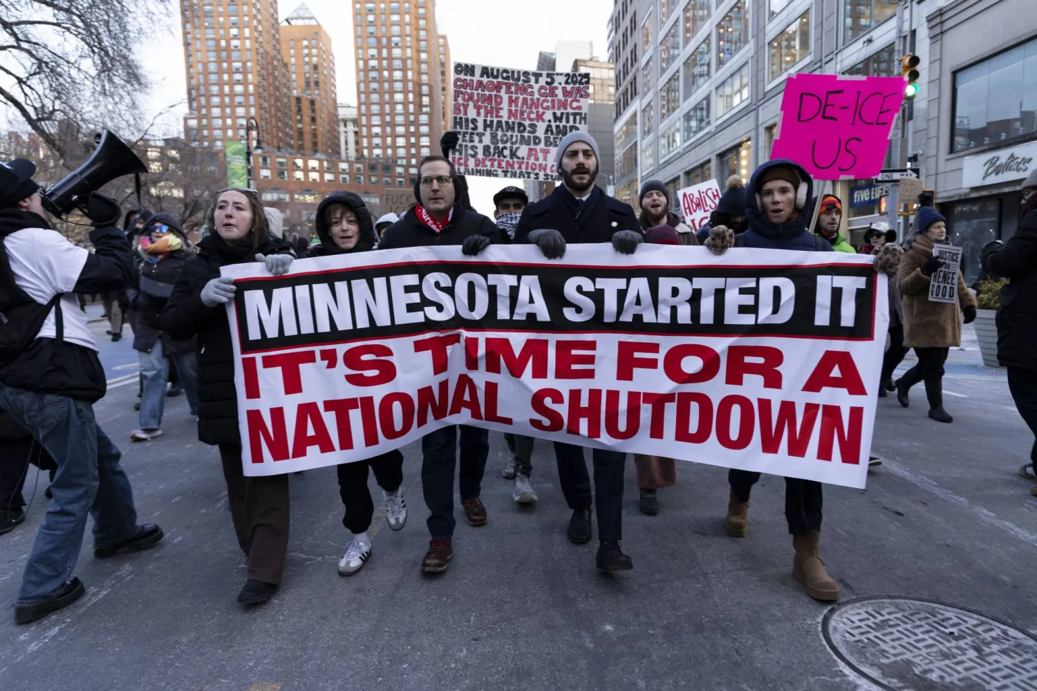 متظاهرون وأفراد من المجتمع رفعوا لافتة كُتب عليها «حان وقت إغلاق وطني» خلال تجمع احتجاجي طارئ في مينابوليس (د.ب.إ)