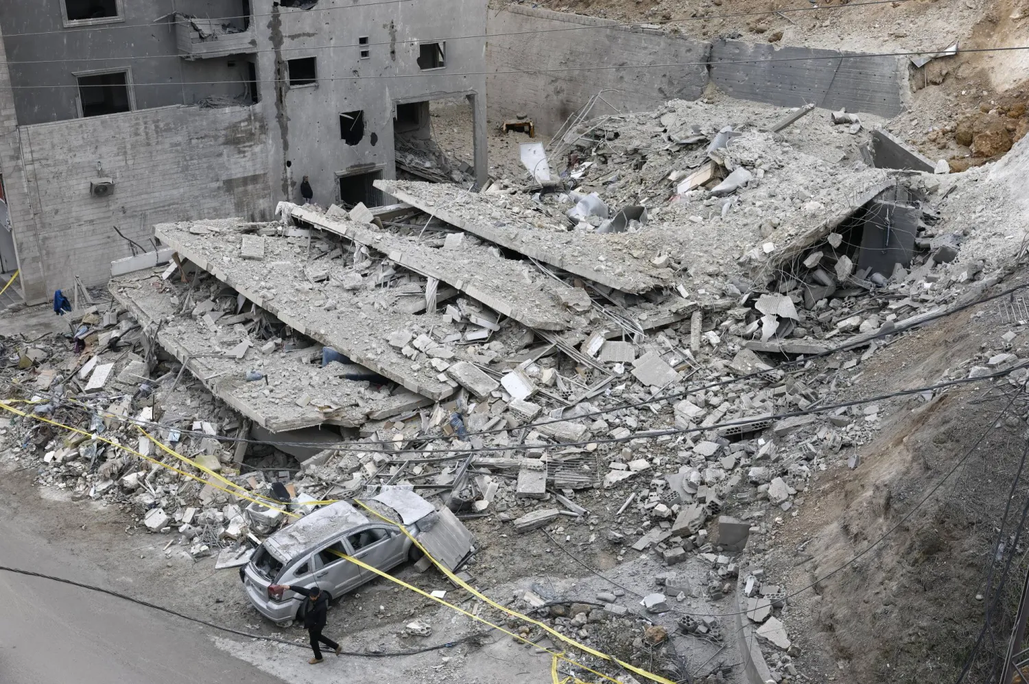 رجل يسير بجوار مبنى مدمر عقب غارة جوية إسرائيلية على قرية قناريت... جنوب لبنان في 22 يناير 2026 (إ.ب.أ)