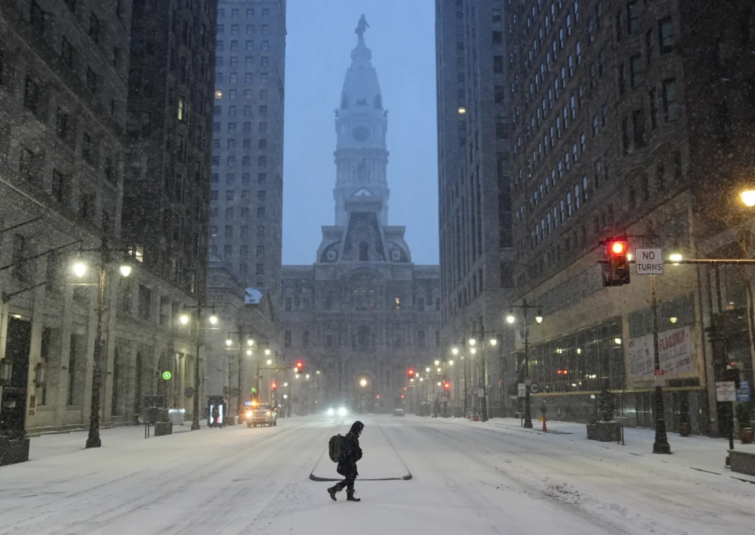 A person walks across a street during a winter storm in Philadelphia, Sunday, Jan. 25, 2026. (AP Photo/Matt Rourke)