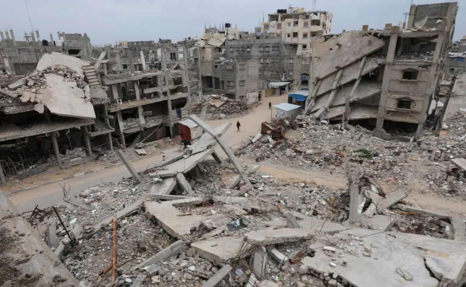 Palestinians walk surrounded by the rubble of houses destroyed in Israeli strikes during the war, in Khan Younis, southern Gaza Strip, January 22, 2026. REUTERS/Ramadan Abed/File Photo
