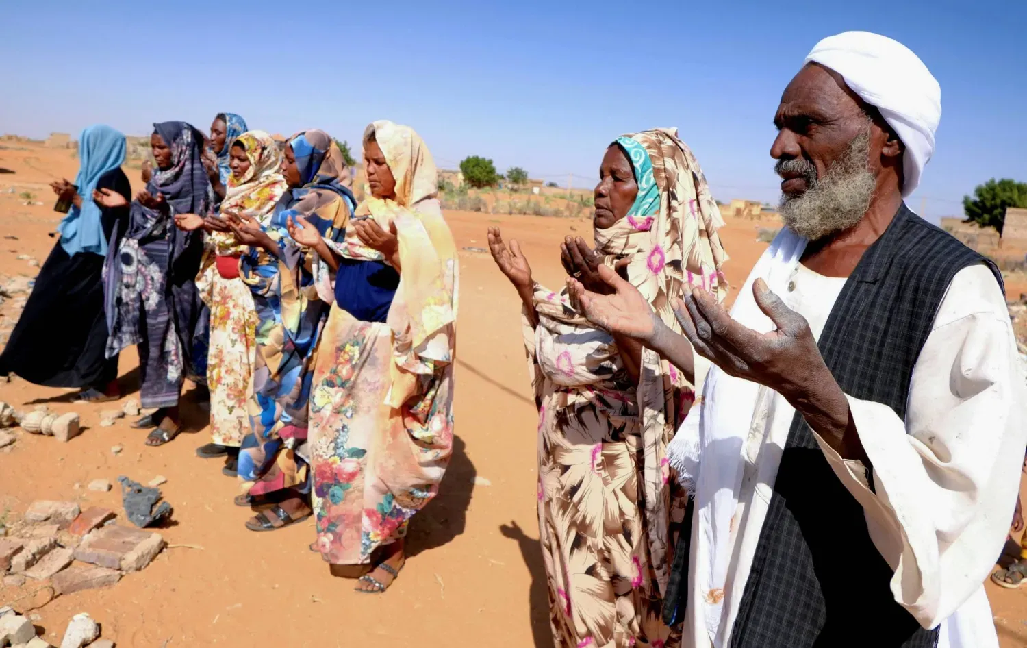 12 Ocak 2026'da Güney Kordofan eyaletinde meydana gelen İHA saldırısının kurbanlarının için dua eden Sudanlılar (Reuters)