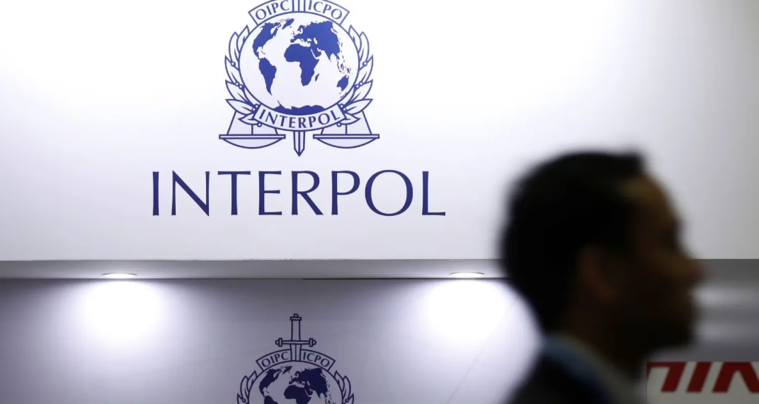 رجل يمر أمام شعار «الإنتربول» (رويترز)