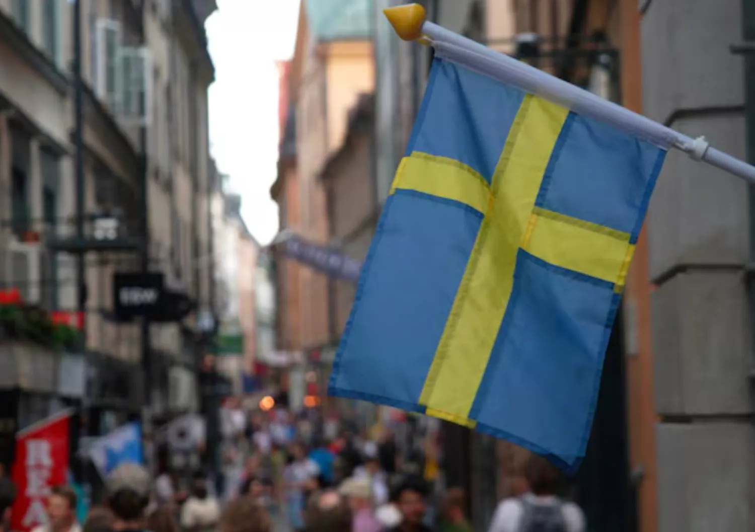 A Swedish flag hangs outside a store on a busy street as visitors walk past in the background in the old town of Stockholm, Sweden, July 14, 2023 REUTERS/Tom Little/File Photo 
