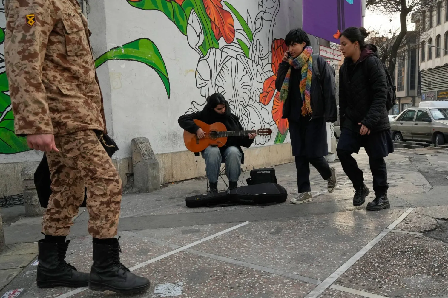 موسيقي يعزف على الغيتار في شارع وسط مدينة طهران (أ.ب)