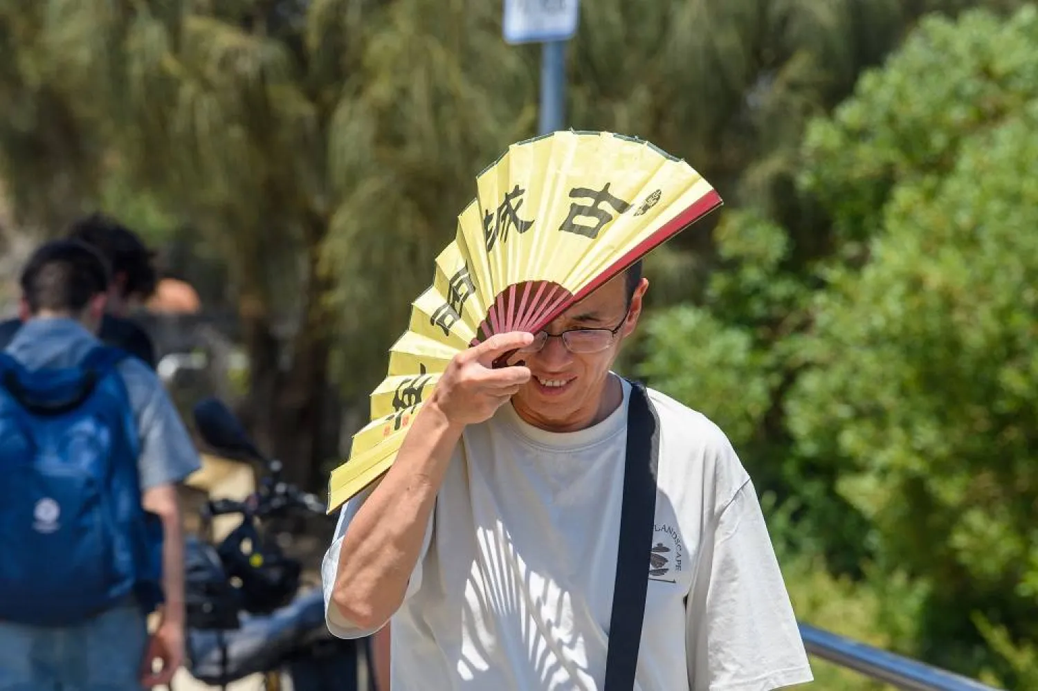 A man shades himself from the heat with a fan in Melbourne, Australia, 27 January 2026. (EPA)