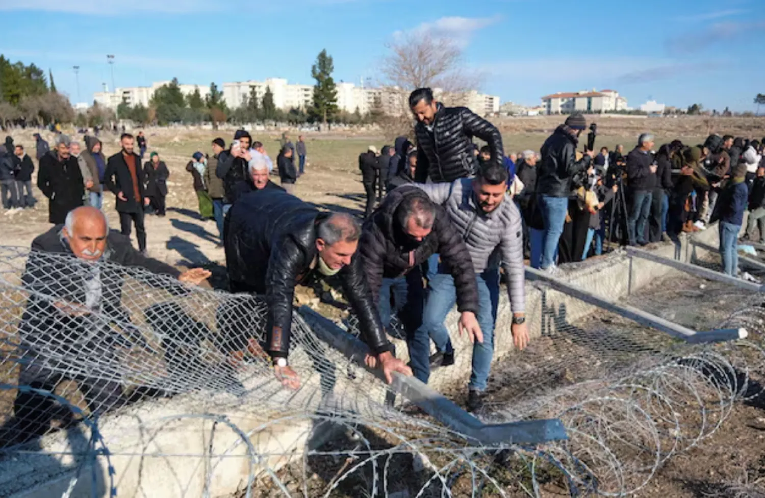 Pro-Kurdish protesters tear down a border fence as they attempt to cross to the Kurdish-controlled northeastern Syrian city of Qamishli during a demonstration in support of Syrian Kurds and against recent military clashes between the Syrian army and Kurdish forces, in Nusaybin, southeastern Türkiye, January 20, 2026. REUTERS/Ensar Ozdemir