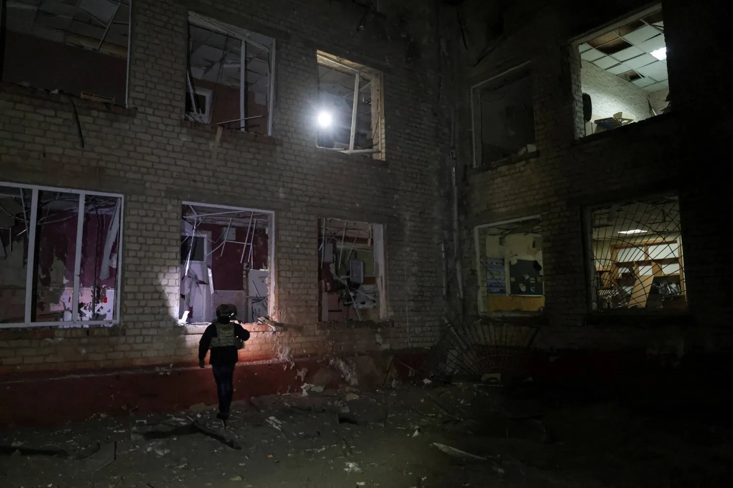 A police officer inspects a building of a school which was hit during late evening Russian missile strikes, amid Russia's attack on Ukraine, in Kharkiv, Ukraine January 26, 2026. (Reuters)