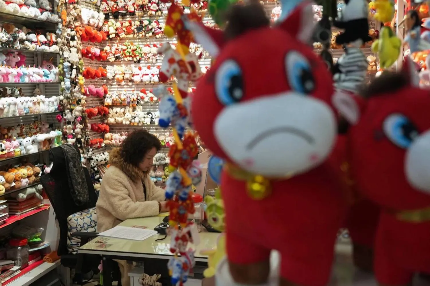 Lou Zhenxian, owner of Vision Plush Toys, works at her desk near crying horse plush toys, ahead of the Chinese Lunar New Year, which will welcome the Year of the Horse, at Yiwu International Trade City in Yiwu, Zhejiang province, China January 21, 2026. REUTERS/Nicoco Chan