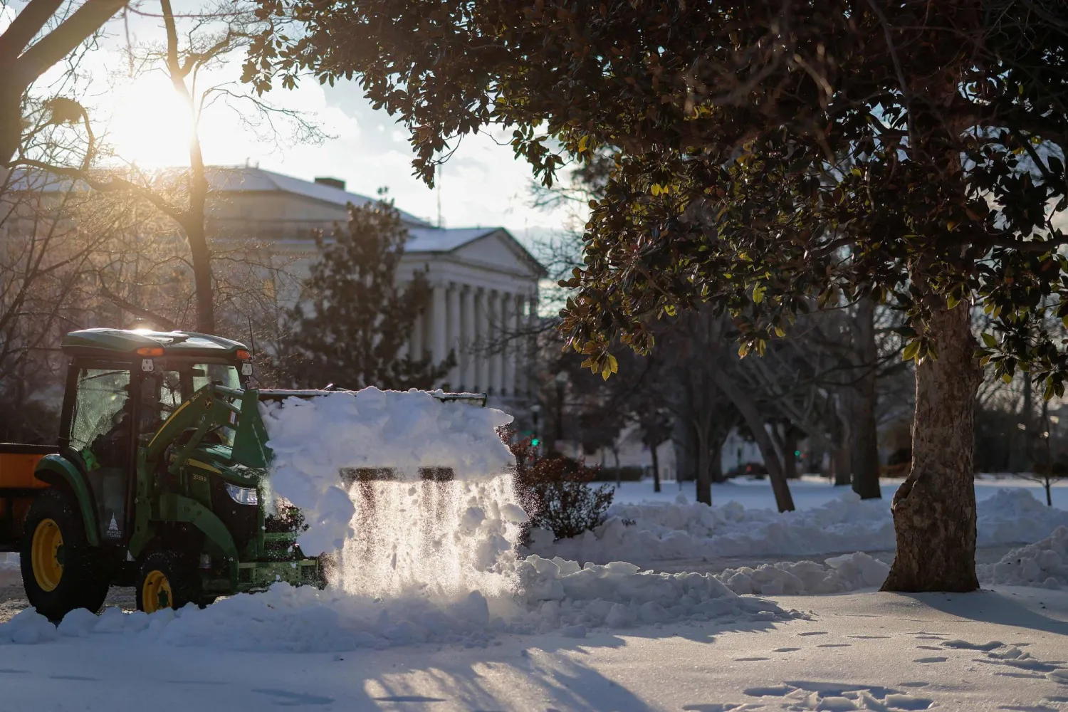 عمال يزيلون الثلوج خارج مبنى الكابيتول (أ.ف.ب)