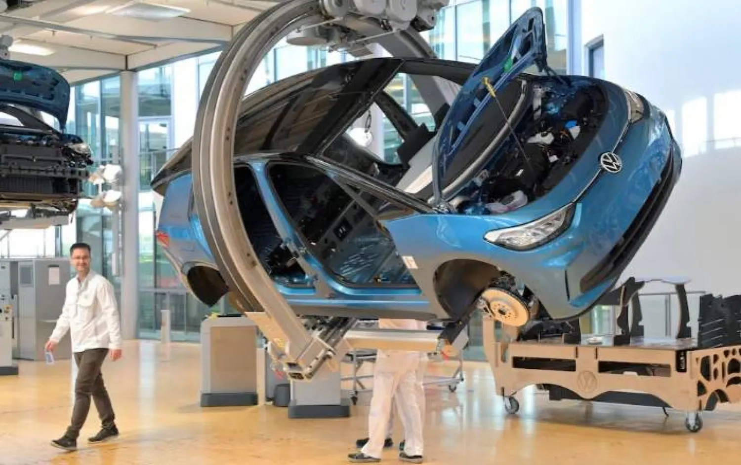 فنيون يعملون على خط تجميع سيارة «فولكس فاغن» الكهربائية «آي دي 3» خلال جولة إعلامية في دريسدن (رويترز)