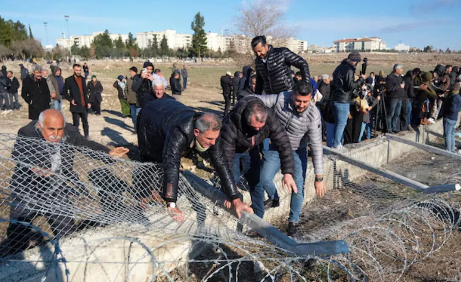 Pro-Kurdish protesters tear down a border fence as they attempt to cross to the Kurdish-controlled northeastern Syrian city of Qamishli during a demonstration in support of Syrian Kurds and against recent military clashes between the Syrian army and Kurdish forces, in Nusaybin, southeastern Türkiye, January 20, 2026. REUTERS/Ensar Ozdemir 