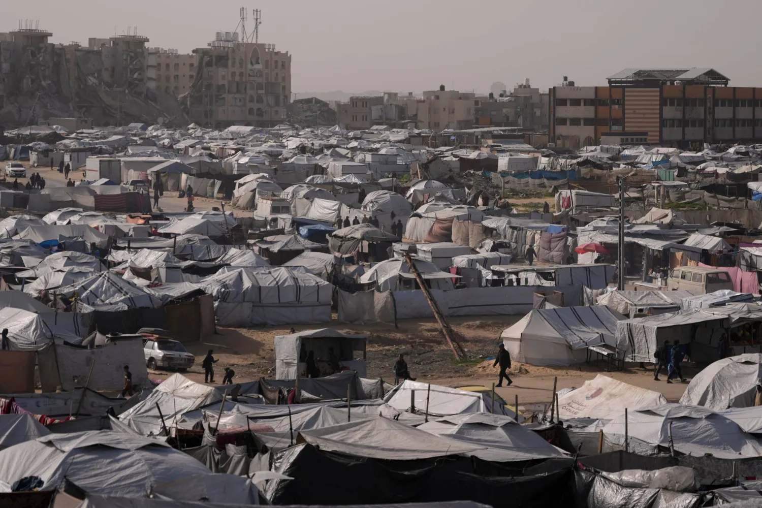  Palestinians walk along tents at a makeshift camp for displaced people in Khan Younis, southern Gaza Strip, Tuesday, Jan. 27, 2026. (AP) 
