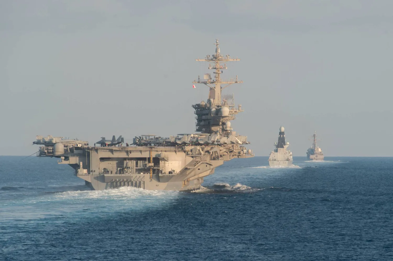The USS Abraham Lincoln aircraft carrier (L) transits the Strait of Hormuz on November 19, 2019. (AFP photo / US Navy / Mass Communication Specialist 3rd Class Zachary Pearson)