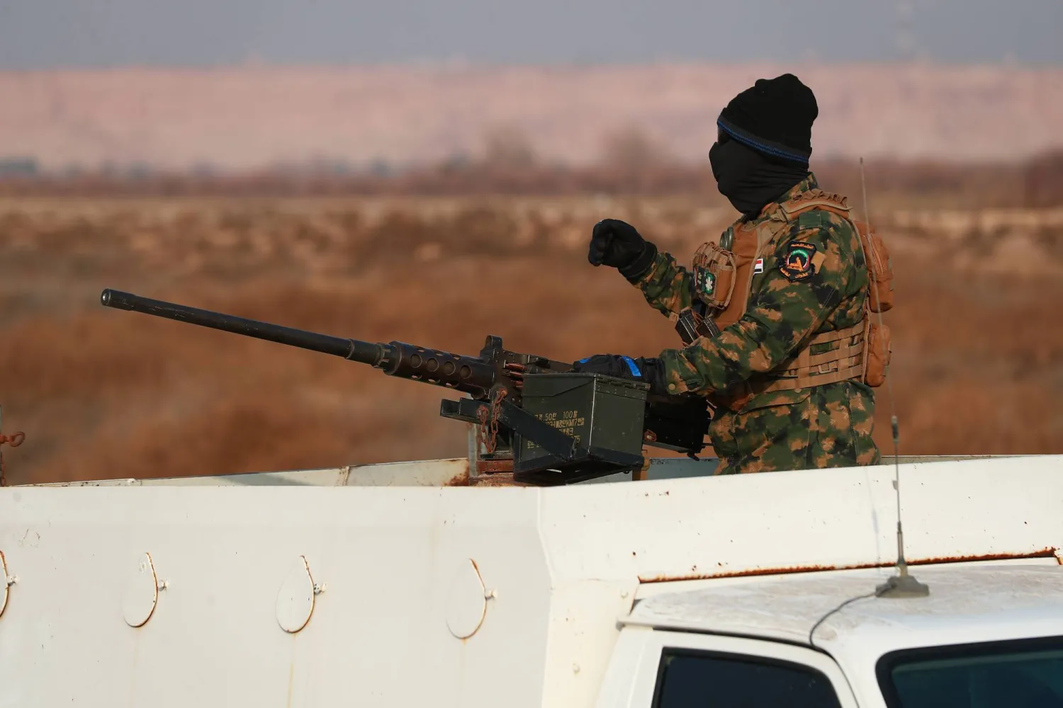 أحد أفراد قوات الحشد الشعبي العراقي يقف بالقرب من جدار خرساني على الحدود العراقية السورية في القائم غرب البلاد (د.ب.أ)