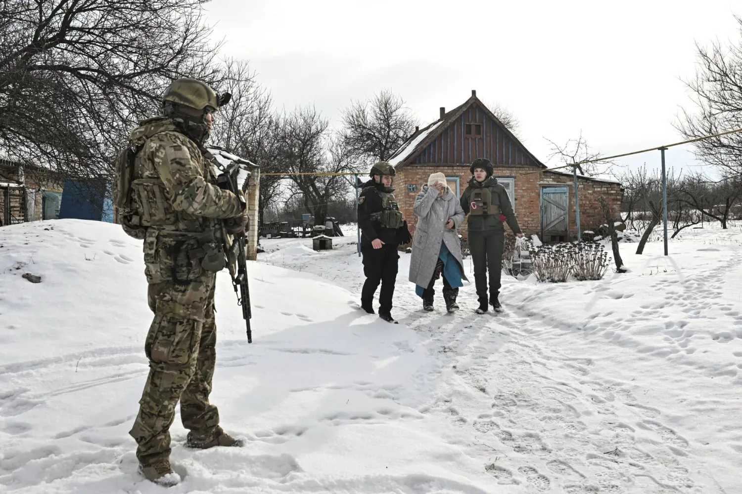 Ukraynalı subaylar, Rusya'nın Ukrayna'ya saldırısı sırasında Zaporijya bölgesinde cephe hattındaki bir köyden vatandaşları tahliye ediyor. (Reuters)
