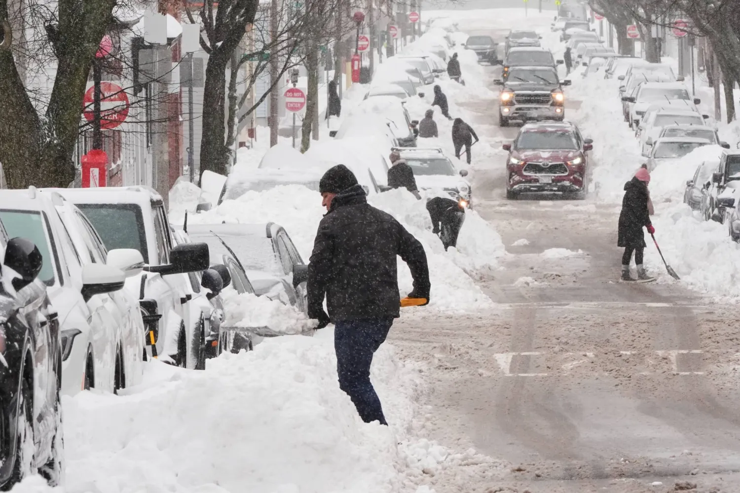Residents dig out their cars in the South Boston neighborhood following a winter storm that dump more than a foot of snow across the region, Monday, Jan. 26, 2026, in Boston. (AP)