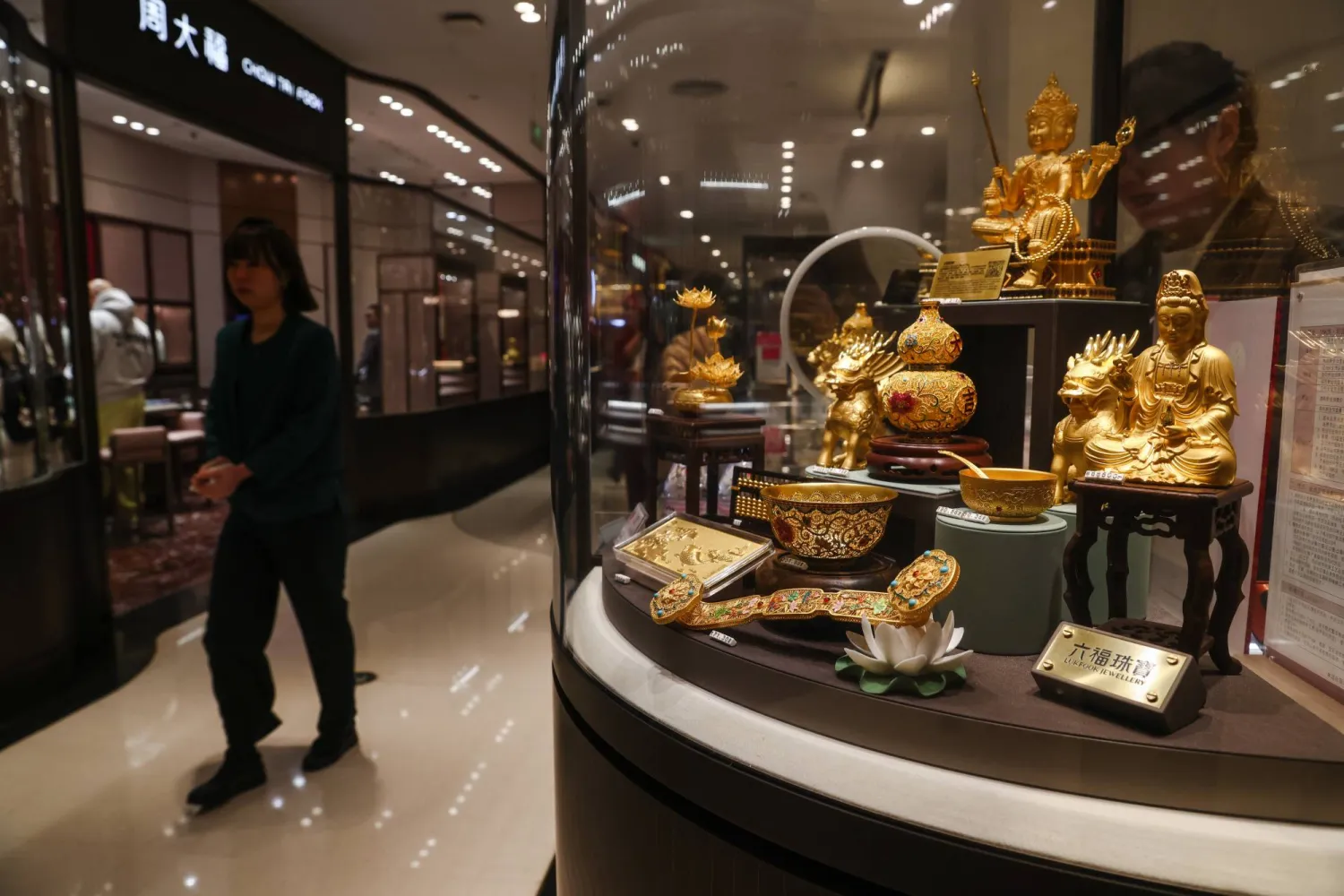 سيدة تمر أمام واجهة أحد متاجر الذهب في العاصمة الصينية بكين (إ.ب.أ)