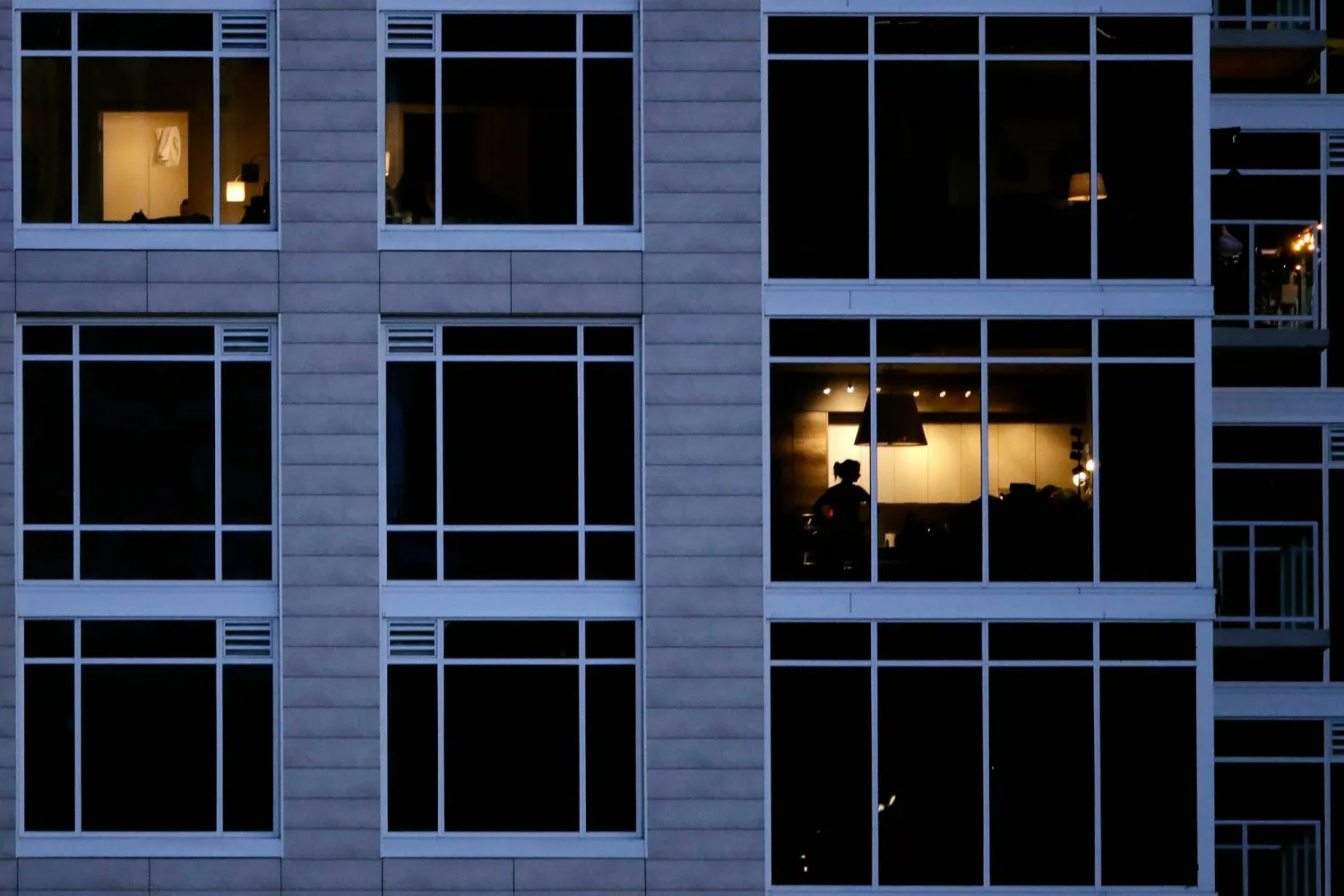 A person looks out of a window in an apartment building in Kansas City, Mo., May 3, 2020. (AP)