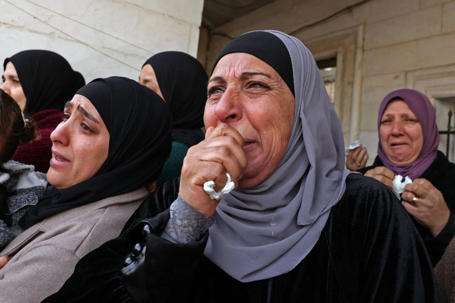 فلسطينيات يبكين الأربعاء خلال جنازة شاب قتلته قوة إسرائيلية في قرية الظاهرة على مشارف مدينة الخليل بالضفة الغربية المحتلة (أ.ف.ب)