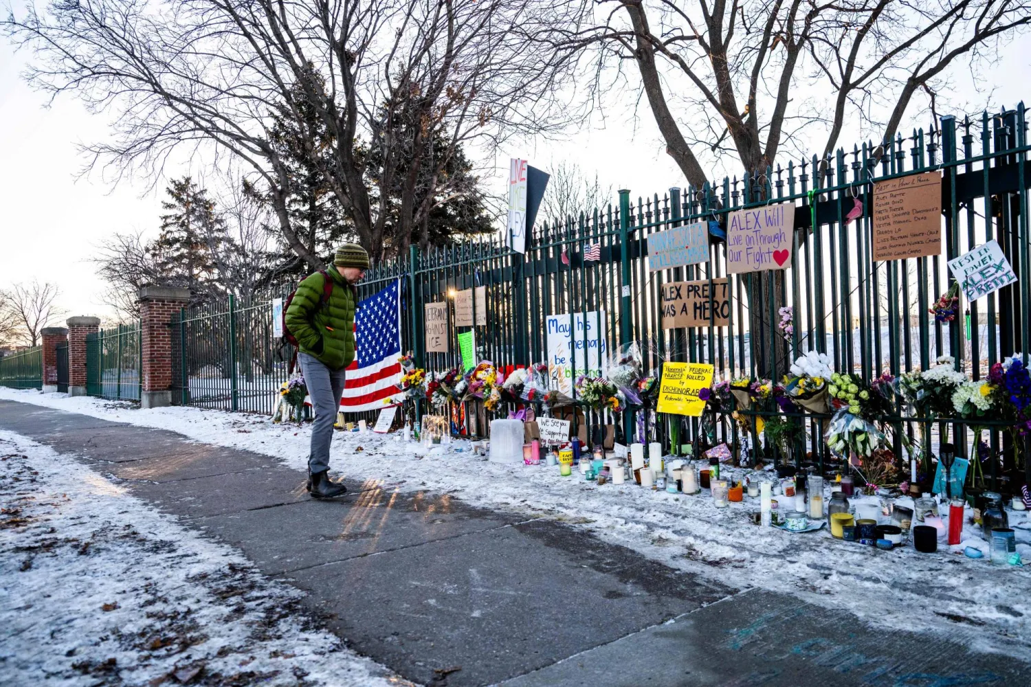 أميركي يقف أمام المركز الطبي الذي كان يعمل فيه أليكس جيفري بريتي (أ.ف.ب)