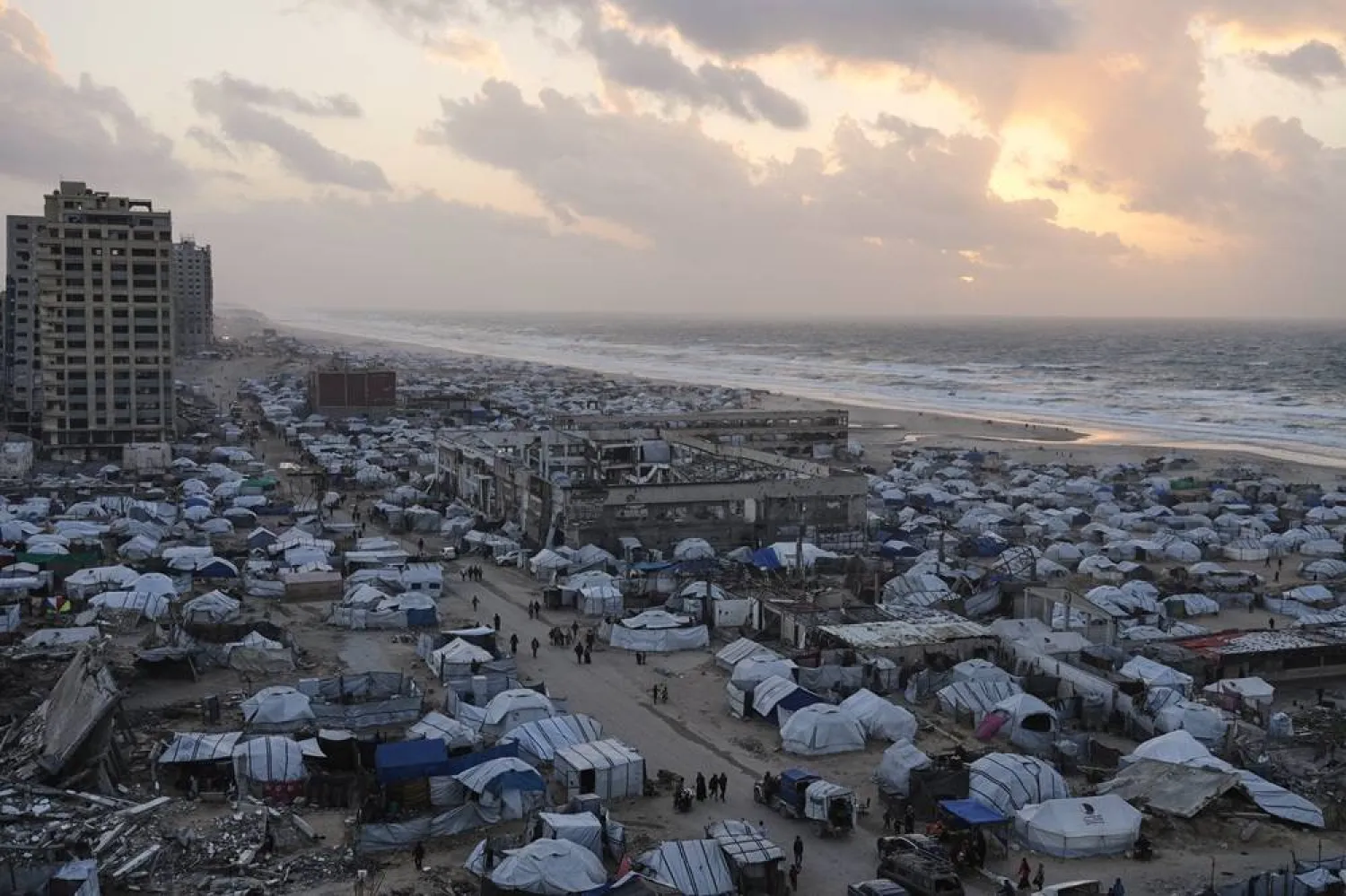  People walk through tents sheltering displaced Palestinians amid the ruins left by the Israeli air and ground offensive in Gaza City, Wednesday, Jan. 28, 2026. (AP)