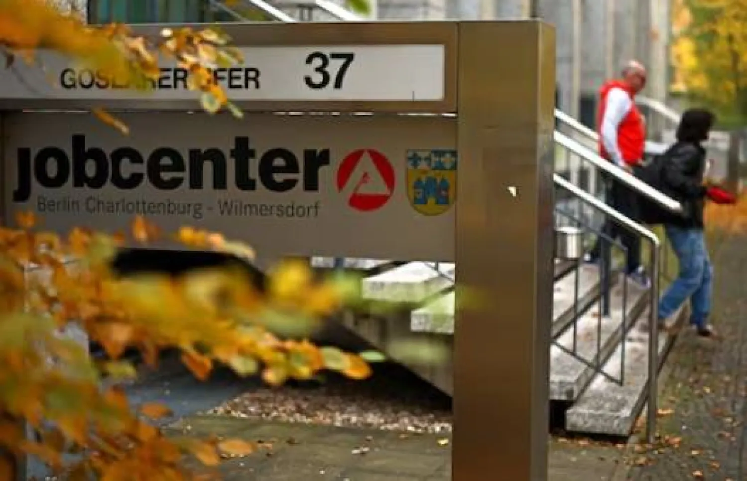 أشخاص يسيرون خارج مركز توظيف في برلين (رويترز)