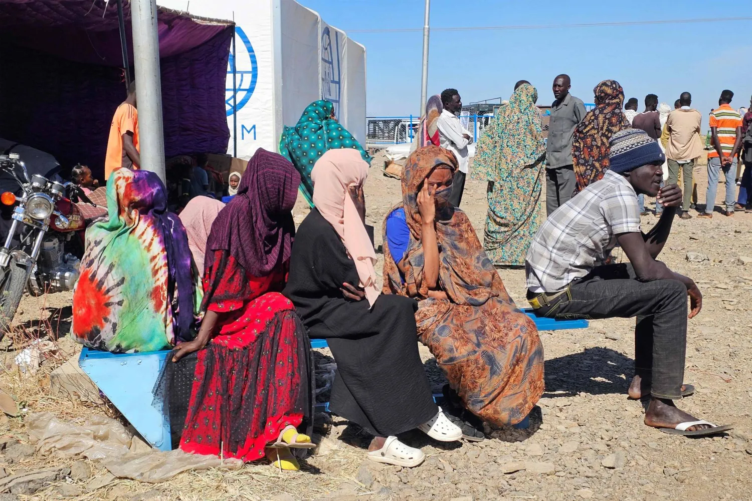 نازحون من منطقة هجليج غرب السودان ينتظرون تلقي مساعدات إنسانية في مخيم «أبو النجا» بولاية القضارف (أ.ف.ب)