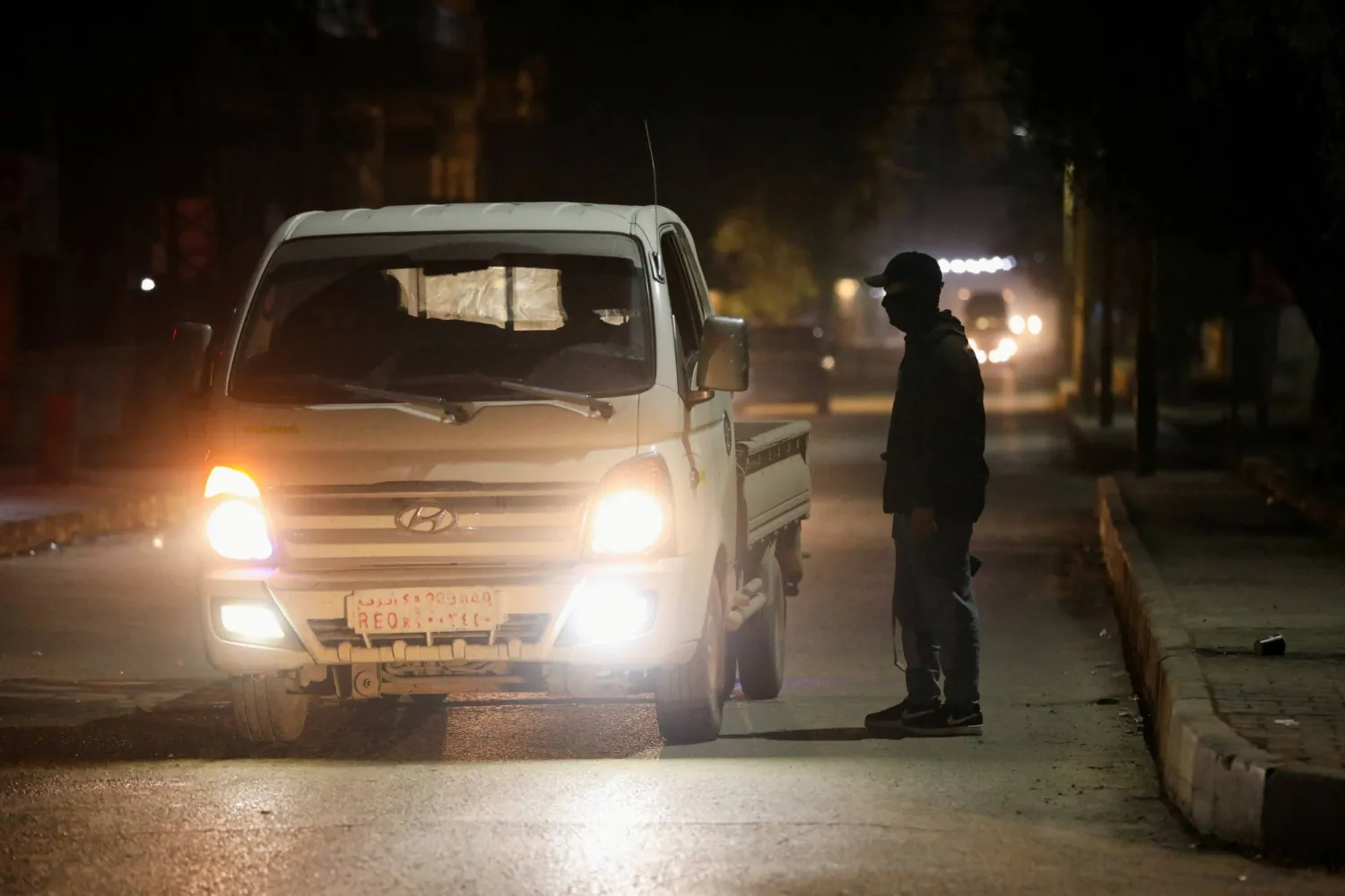 مسلح كردي يقف عند نقطة تفتيش في القامشلي (رويترز)