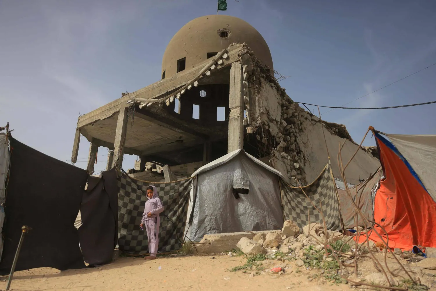 طفلة بجانب منزل مدمر جراء الضربات الإسرائيلية في خان يونس (أ.ف.ب)