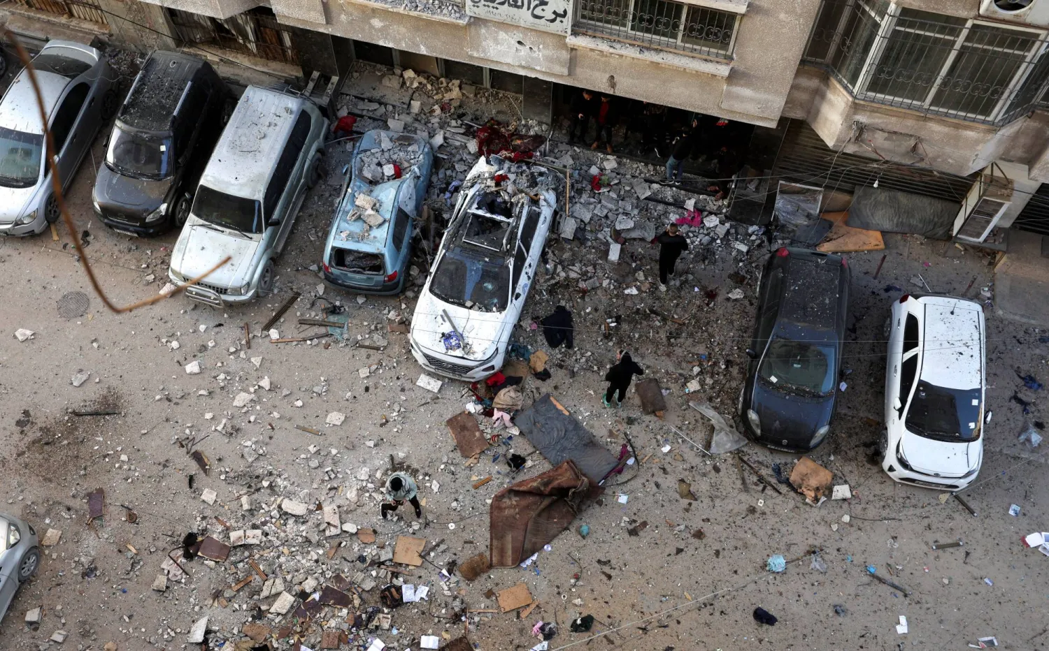 فلسطينيون يتفقدون موقع الغارة الإسرائيلية على مدينة غزة اليوم (رويترز)