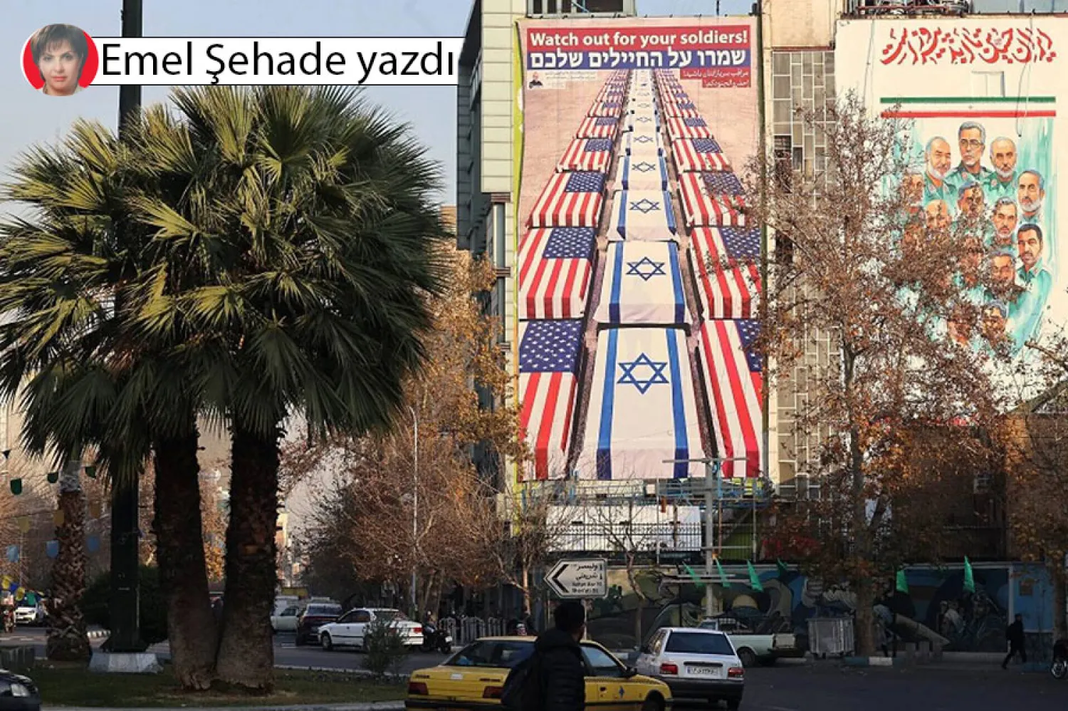 ABD ve İsrail karşıtı sloganların yazılı olduğu bir billboradın önünden geçen İranlılar (AFP)