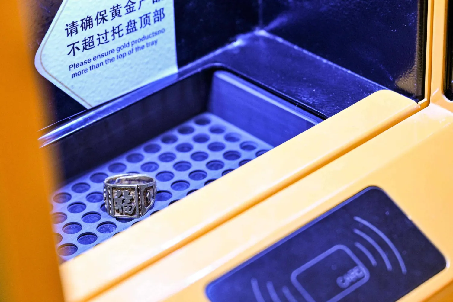 A gold ring is placed in a Smart Gold Store Machine where a customer has brought it to sell in Shanghai on January 29, 2026. (AFP)