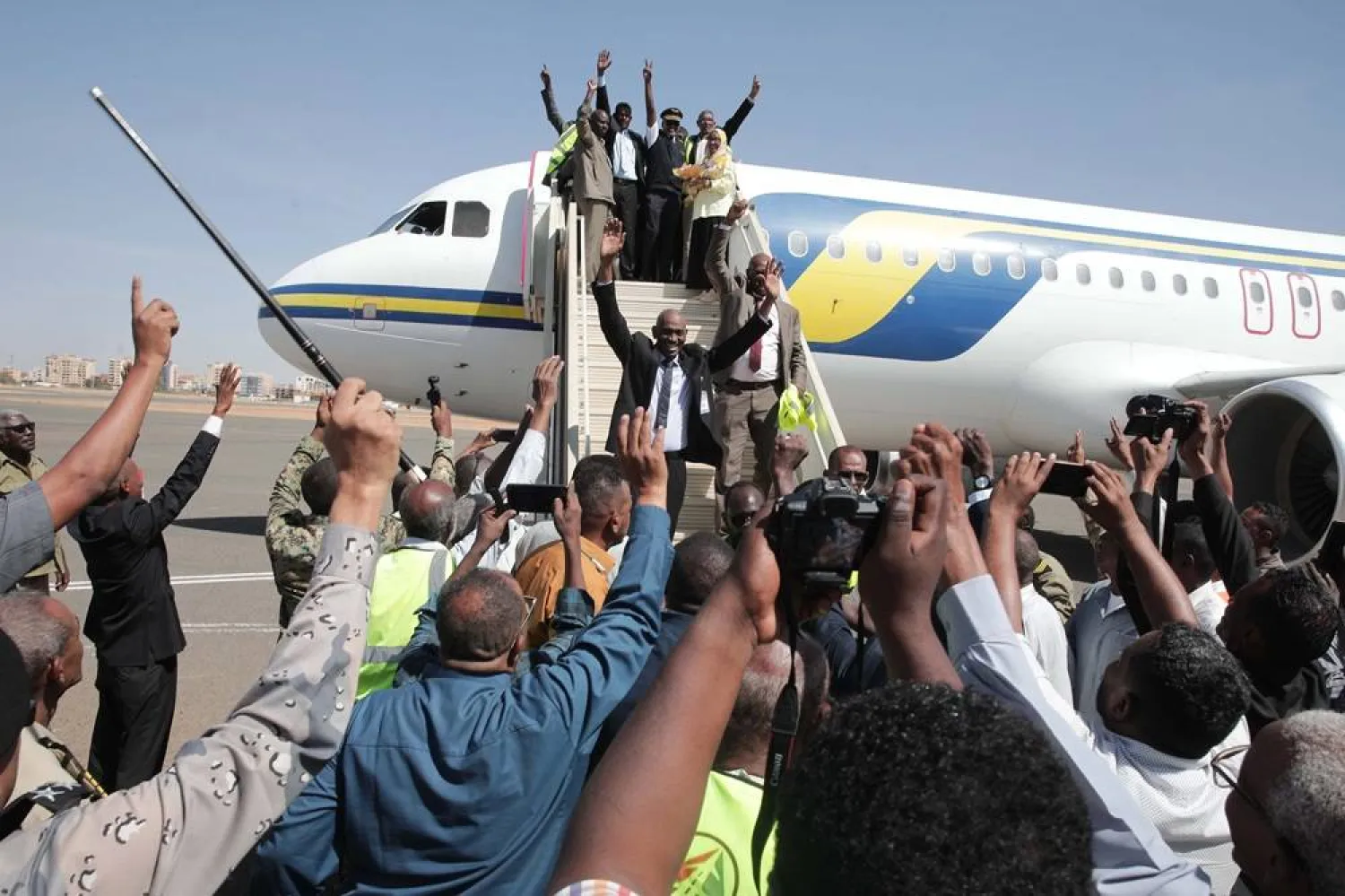 Family and friends rush on the tarmac to greet the domestic Sudan Airways flight arriving from Port Sudan, after landing at Khartoum International Airport, following the war between Sudan's army and the paramilitary Rapid Support Forces, in Khartoum, Sudan, Sunday, Feb. 1, 2026. (AP) 