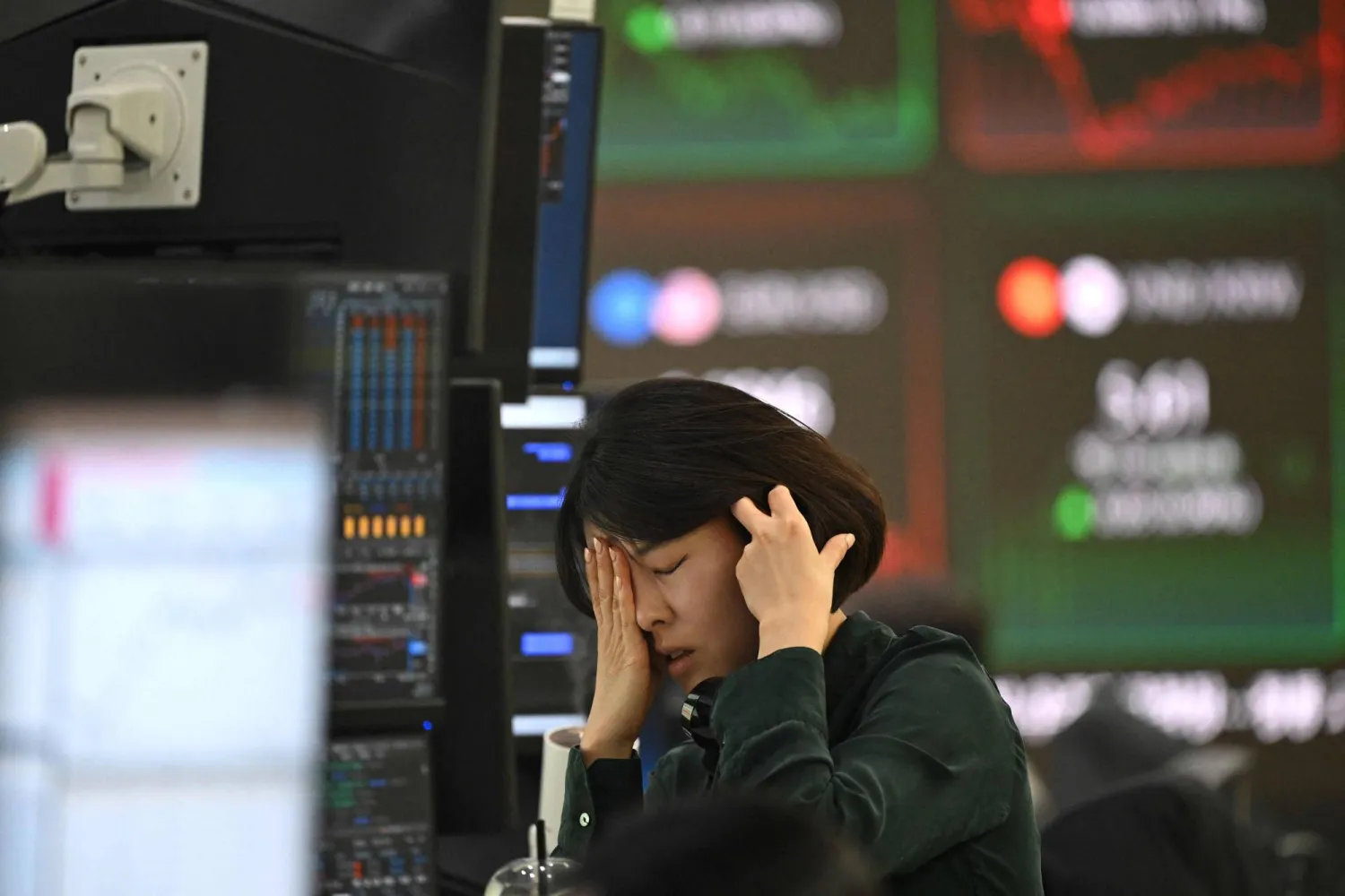 متداولة تتفاعل في سوق العملات أثناء متابعتها لأسعار الصرف بالمقر الرئيسي لبنك هانا في سيول (أ.ف.ب)