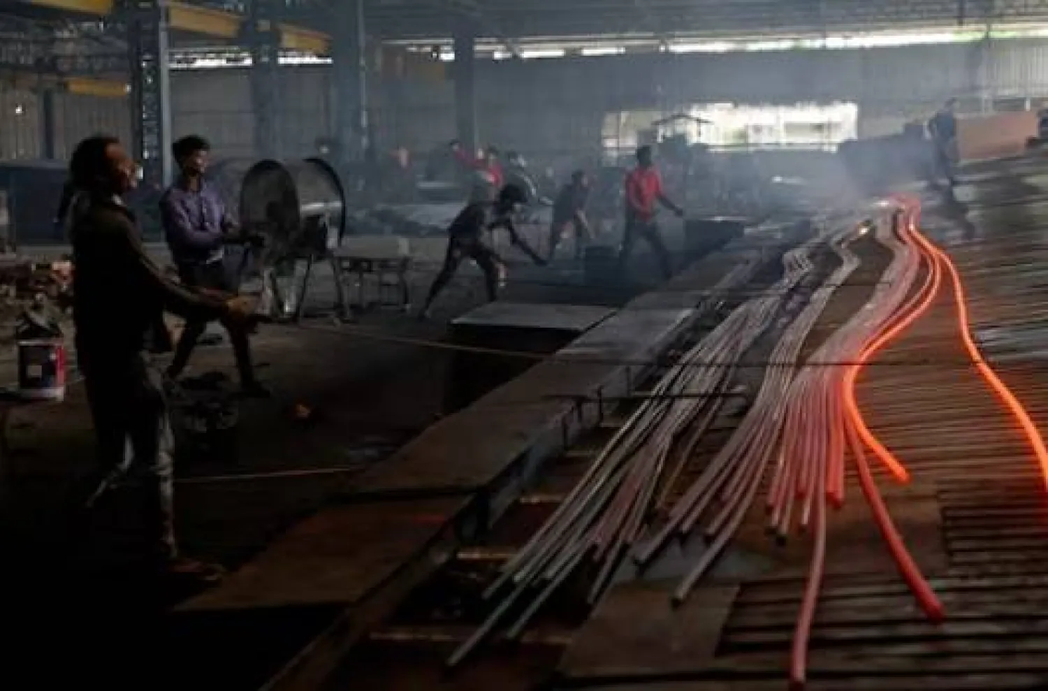 عاملون على خط إنتاج لمعالجة الصلب بمصنع في مدينة ماندي جوبيندغاره بولاية البنجاب الشمالية الهندية (رويترز)