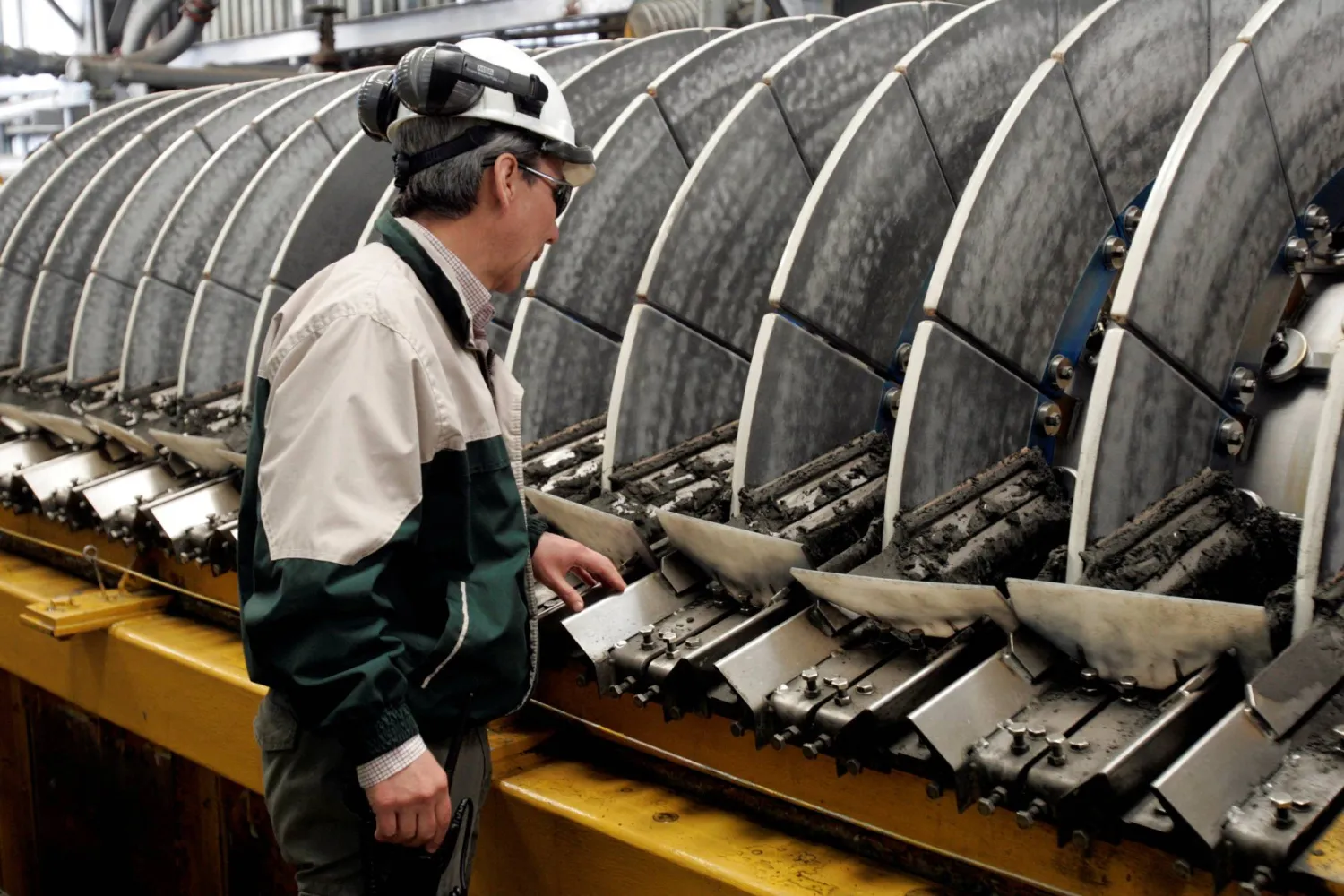 عامل يتفقد مركزات النحاس في ميناء بونتا تشونغو المستخدمة لتصدير النحاس من منجم لوس بيلامبريس الرئيسي (رويترز)