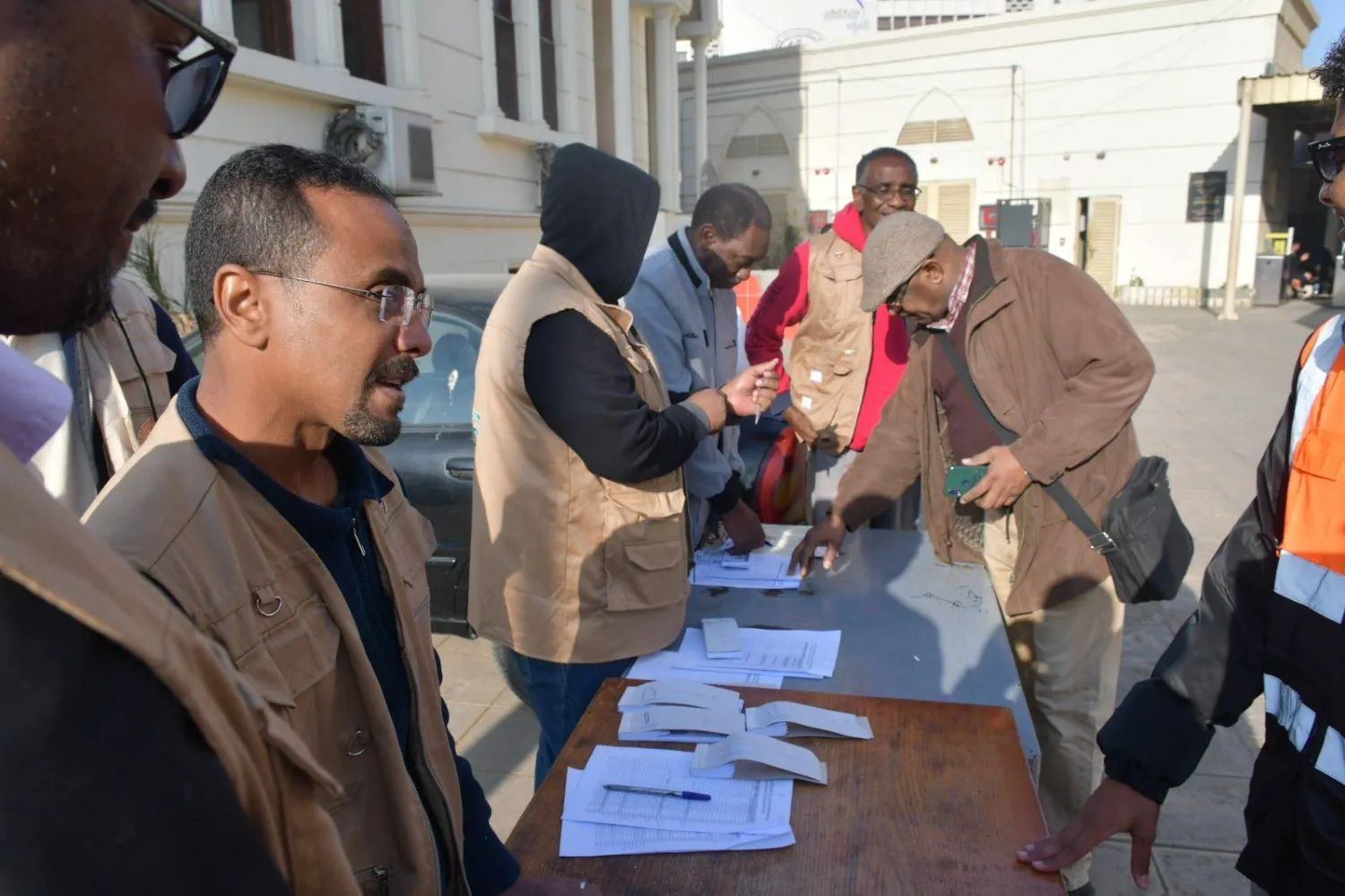 سودانيون يبحثون عن أسمائهم في قائمة المسافرين ضمن الرحلة 43 لقطارات العودة (رئاسة مجلس الوزراء المصري)