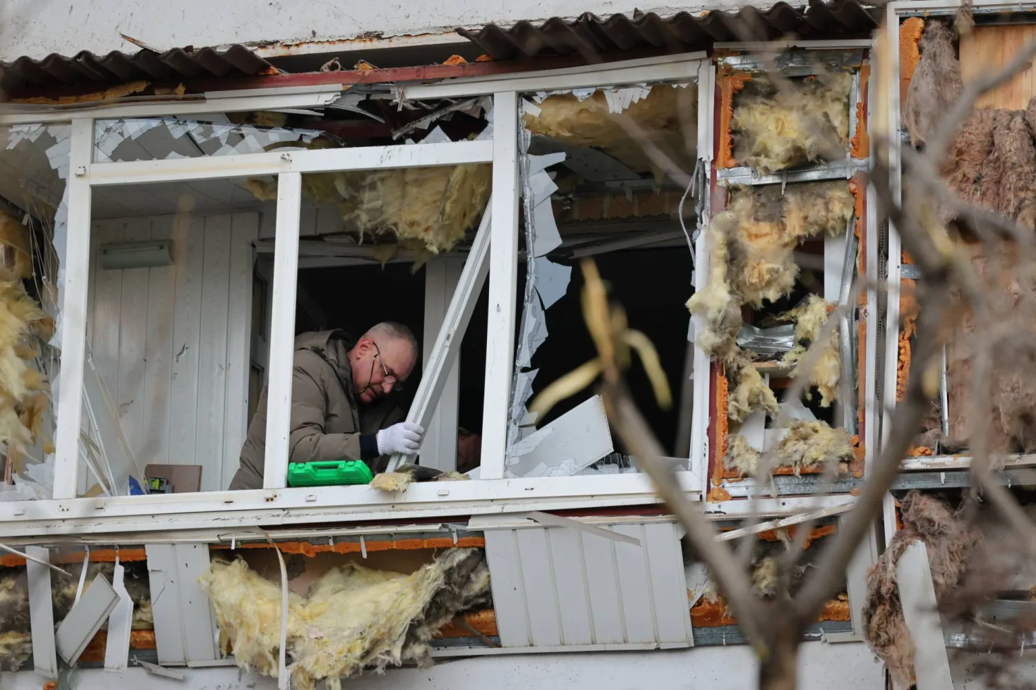 A local resident clears up debris from his broken balcony after a Russian attack in Zaporizhzhia, Ukraine, Wednesday, Jan. 28, 2026. (AP Photo/Kateryna Klochko)