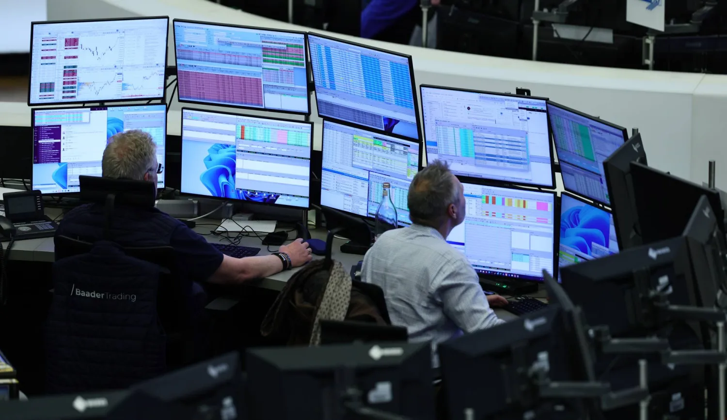 يجلس وسطاء الأسهم على المكاتب في قاعة التداول ببورصة فرانكفورت (إ.ب.أ)
