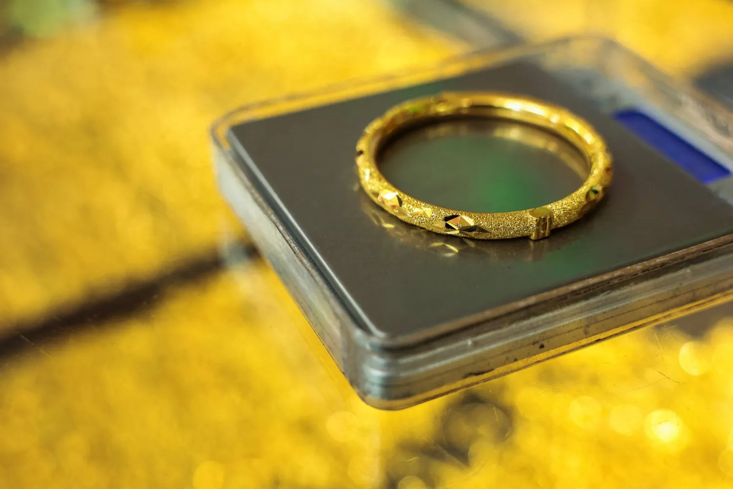 بائع يزن سواراً ذهبياً للبيع لعميل بمتجر ذهب في بانكوك بتايلاند (رويترز)