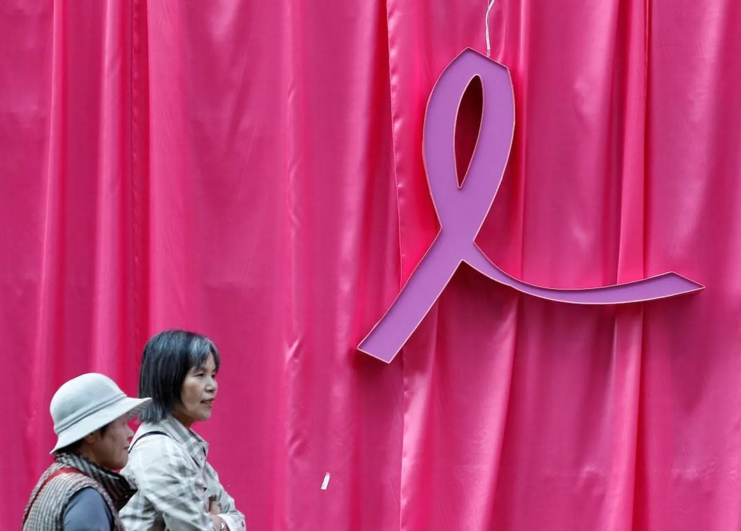 Visitors walk past a sculpture of a pink ribbon installed to promote the "Pink Ribbon" breast cancer awareness campaign in this illustration, October 5, 2011. (Reuters) 